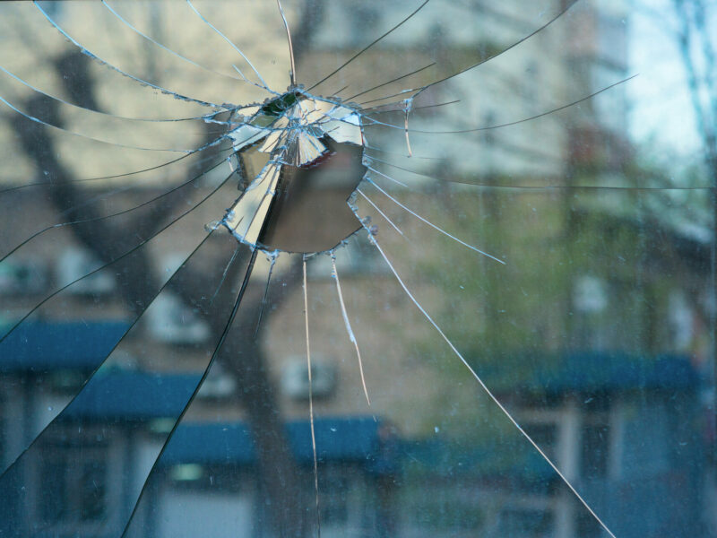 reflection of street in broken glass on window
