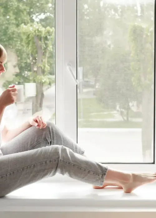 woman listens music drinks from cup window ergebnis